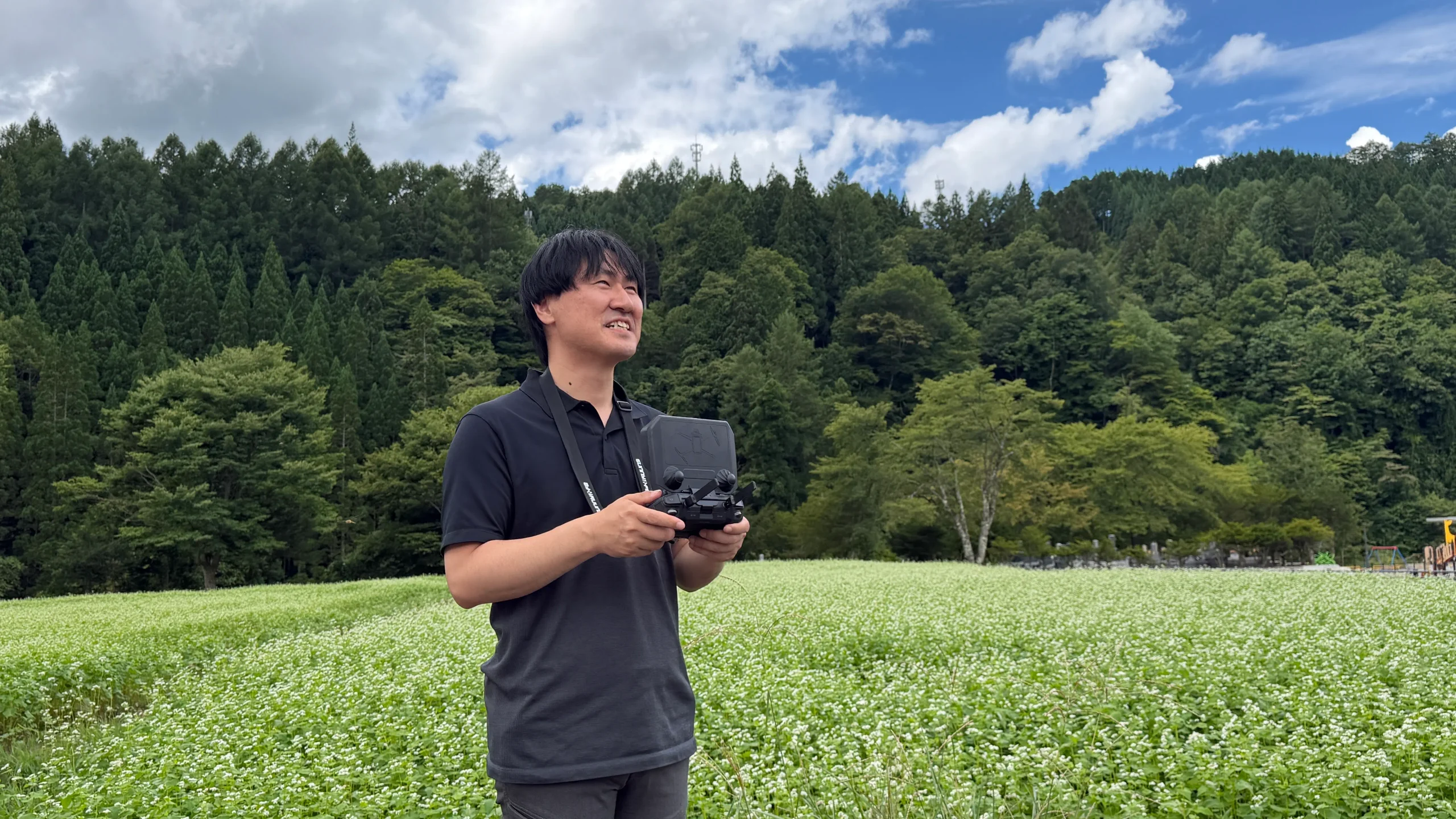 自然の中でドローンを操縦する代表取締役の大澤壮登